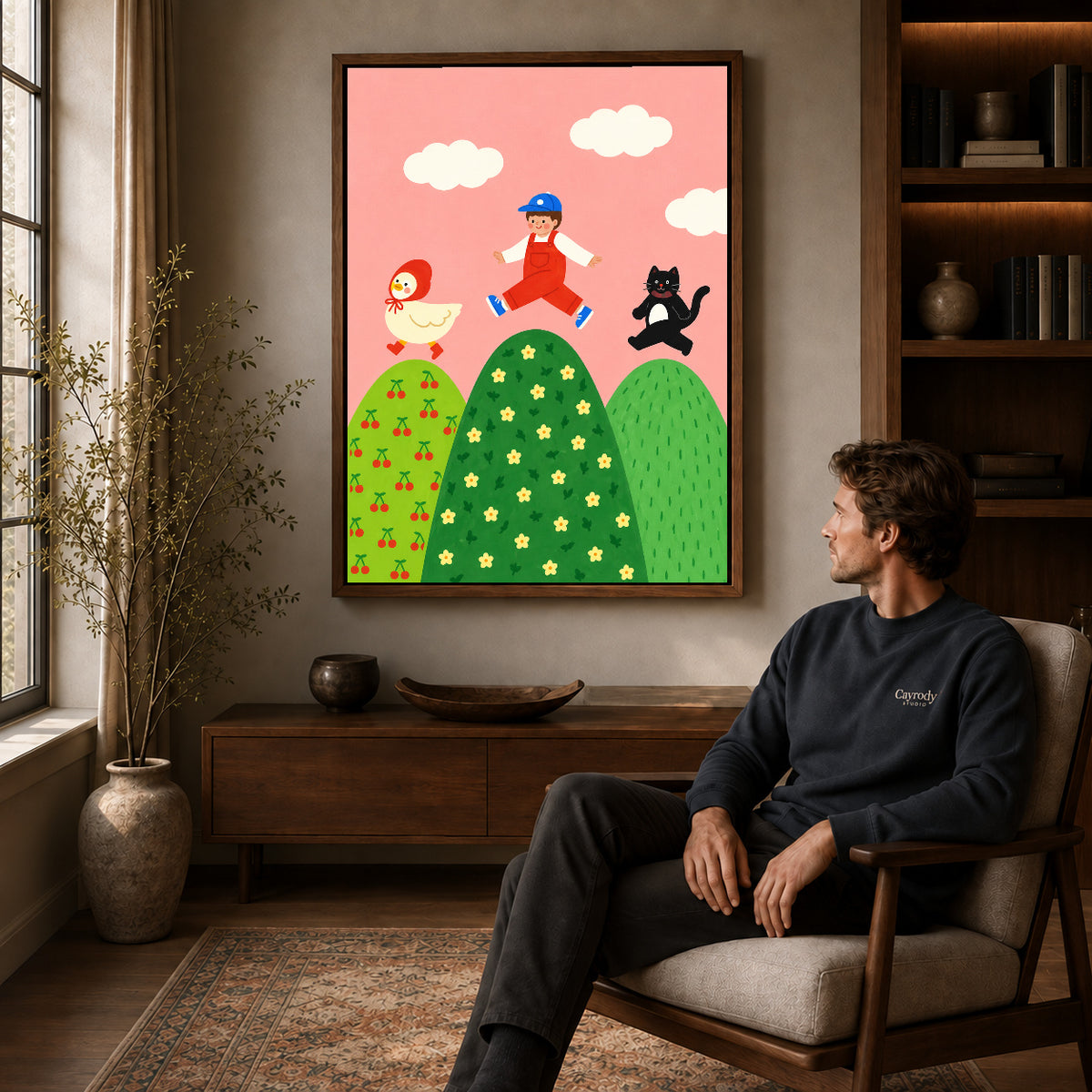 playful hilltop friends canvas art in a walnut frame above a console beside a seated man.