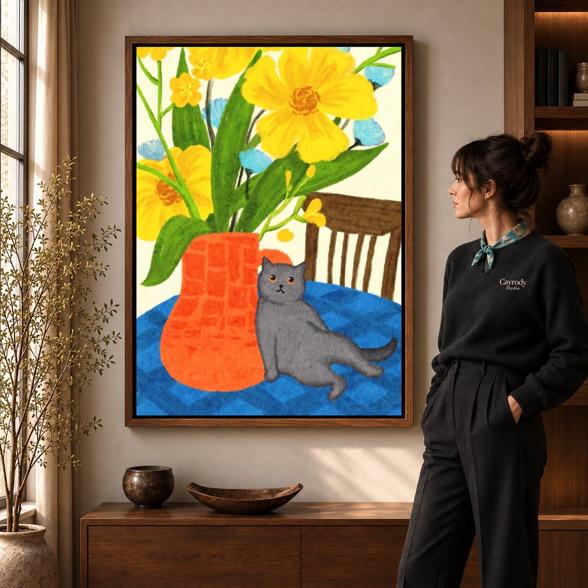 expressive floral cat canvas art in a walnut frame beside a standing woman and wooden console.