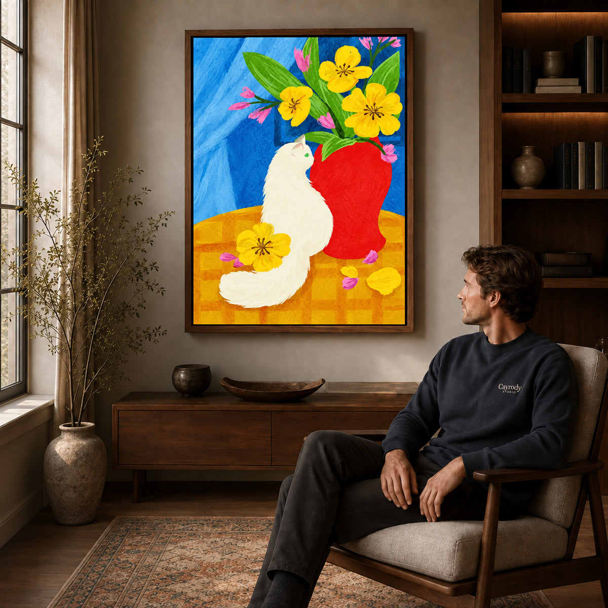 painterly white cat canvas art in a walnut frame above a console beside a seated man.