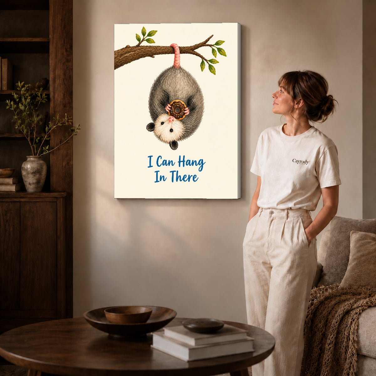 whimsical donut opossum canvas art on gallery-wrapped canvas with natural edge shading beside a standing woman.