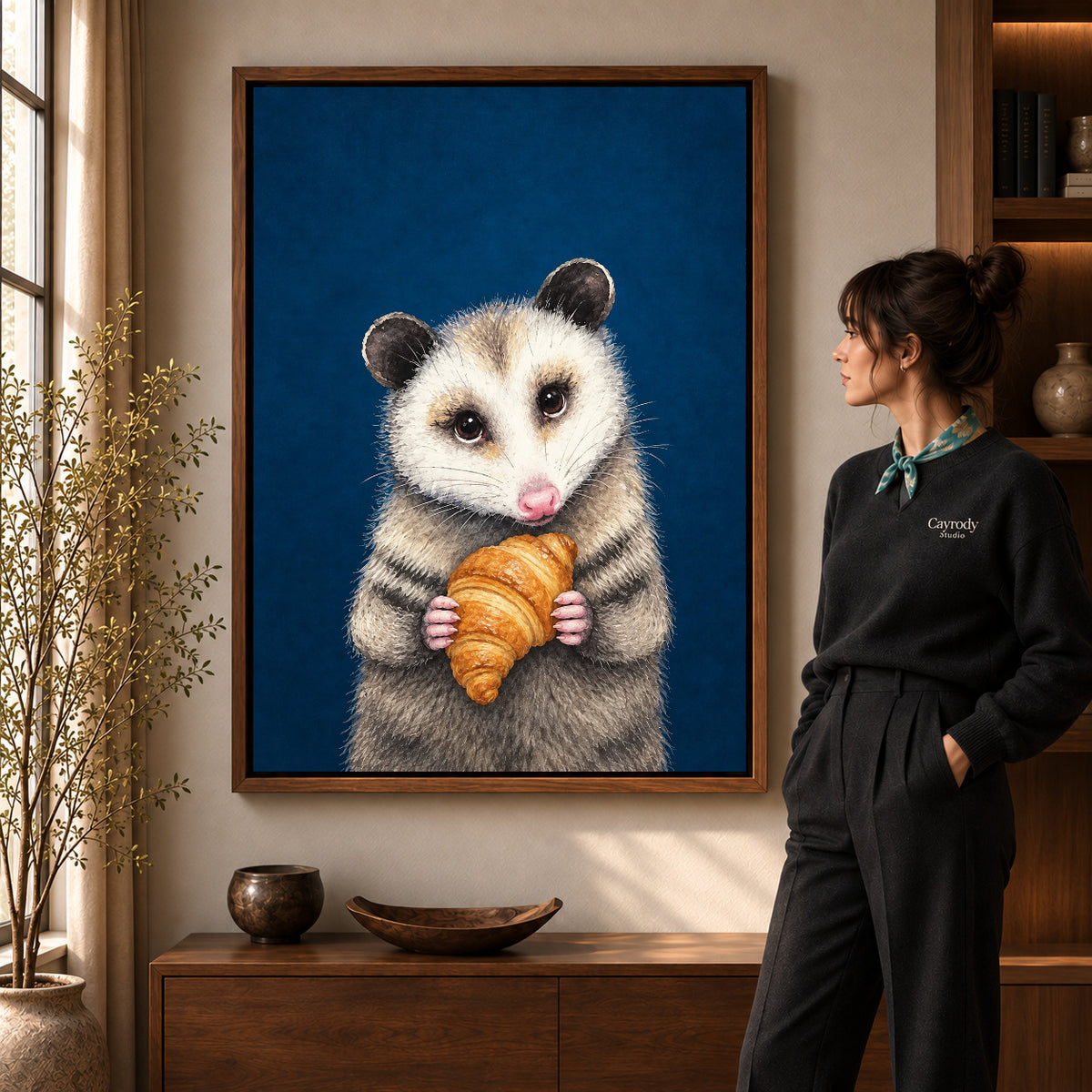 croissant opossum portrait canvas art in a walnut frame beside a standing woman and wooden console.