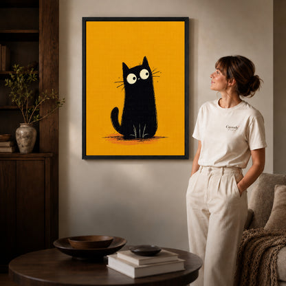 minimalist mustard cat canvas art in a black frame beside a woman and round wooden table.