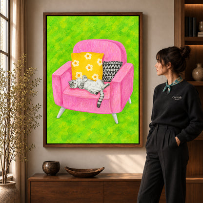 playful reclining cat canvas art in a walnut frame beside a standing woman and wooden console.