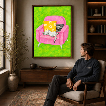 playful reclining cat canvas art in a walnut frame above a console beside a seated man.