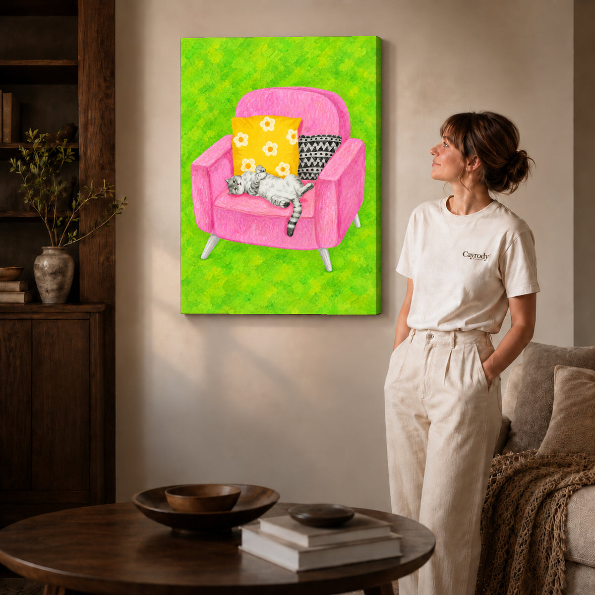 playful reclining cat canvas art on gallery-wrapped canvas with natural edge shading beside a standing woman.