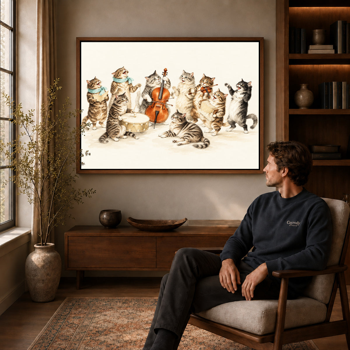 vintage cat orchestra canvas art in a walnut frame above a console beside a seated man.