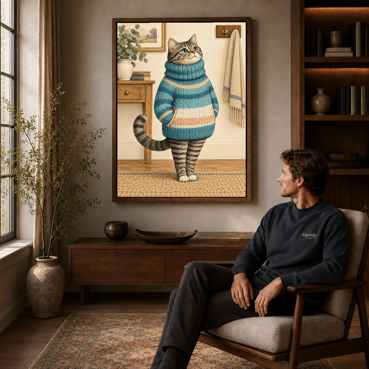 vintage sweater tabby canvas art in a walnut frame above a console beside a seated man.