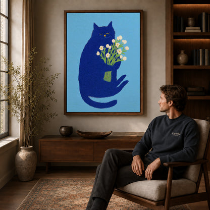blue cat with flowers canvas art in a walnut frame above a console beside a seated man.