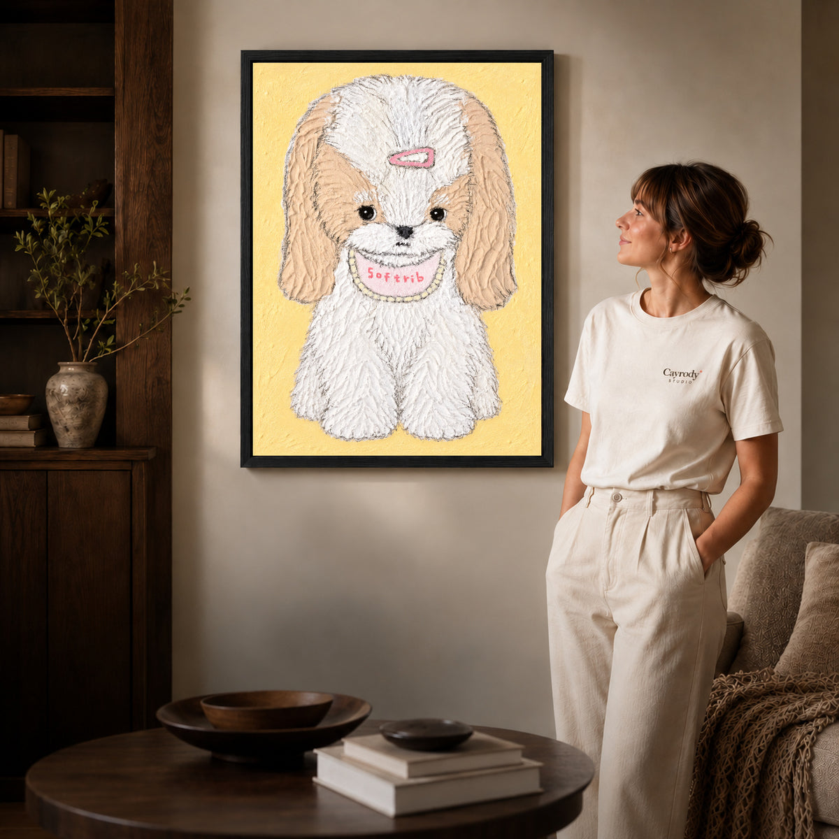 sweet long eared puppy canvas art in a black frame beside a woman and round wooden table.