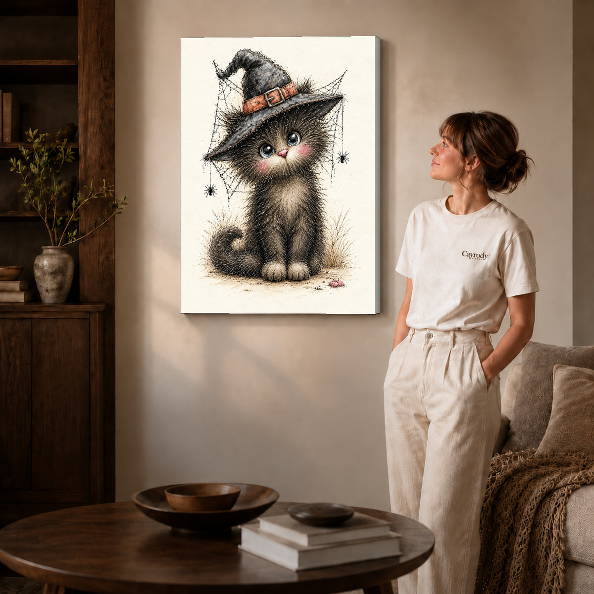 whimsical witch kitten canvas art on gallery-wrapped canvas with natural edge shading beside a standing woman.