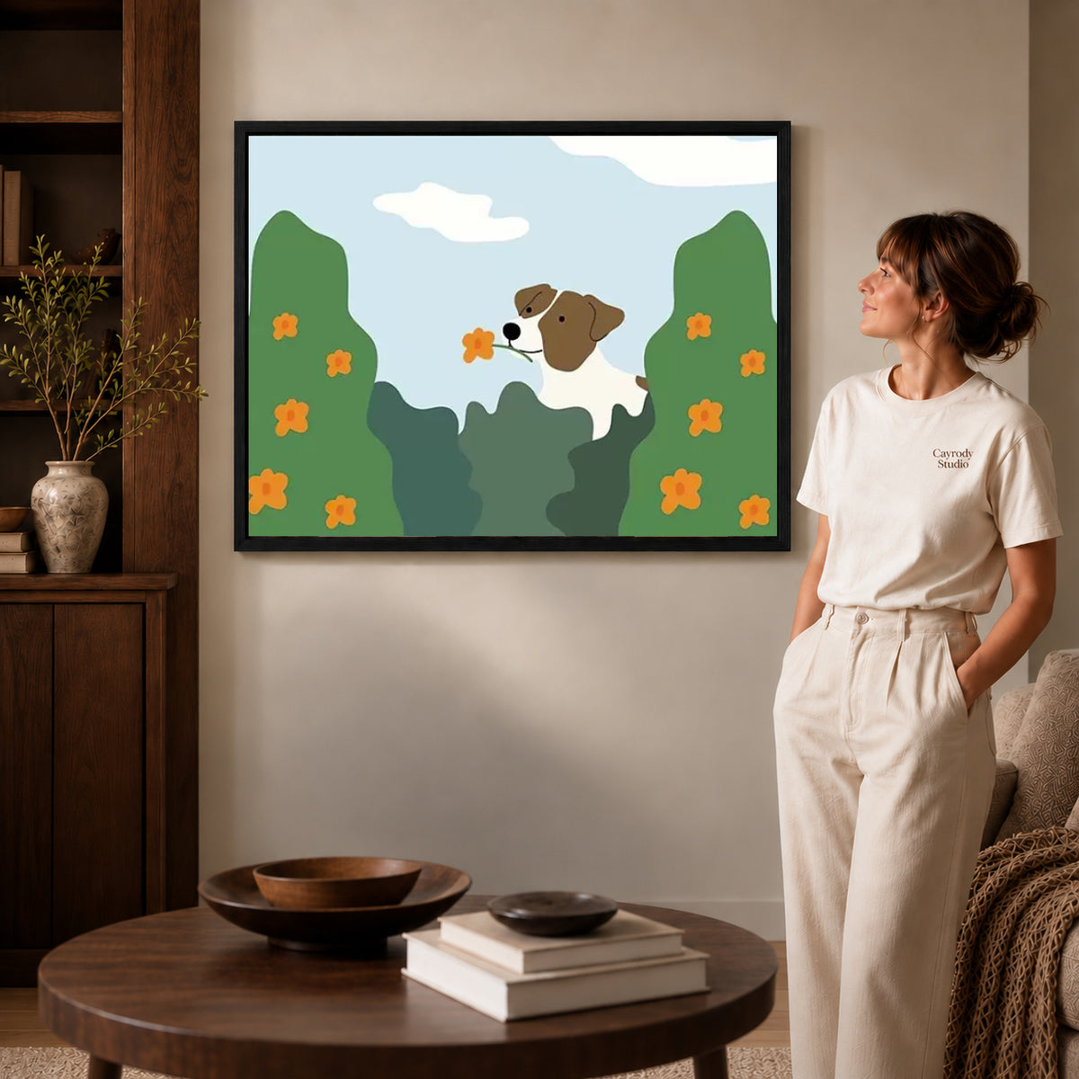 gentle garden dog canvas art in a black frame beside a woman and round wooden table.