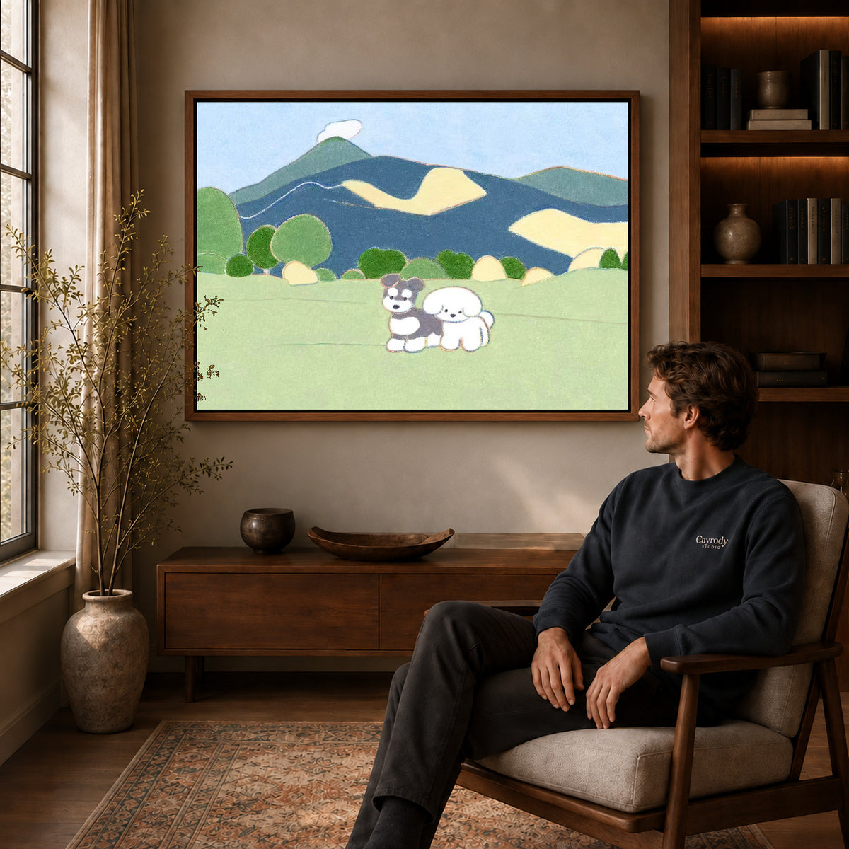 peaceful mountain dogs canvas art in a walnut frame above a console beside a seated man.