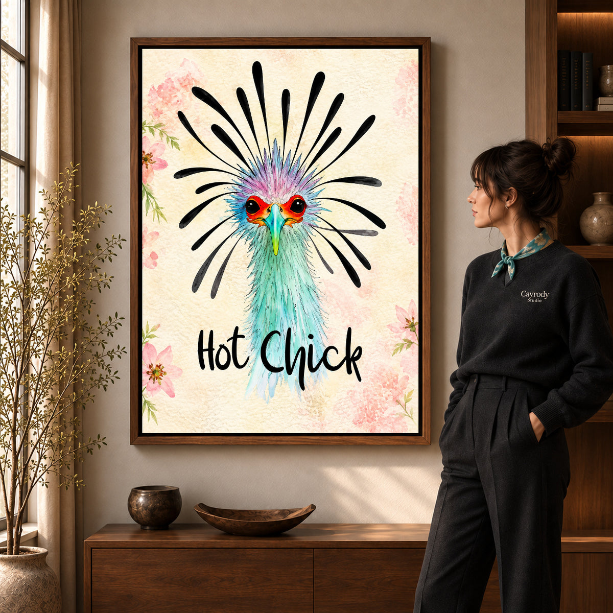 playful hot chick canvas art in a walnut frame beside a standing woman and wooden console.