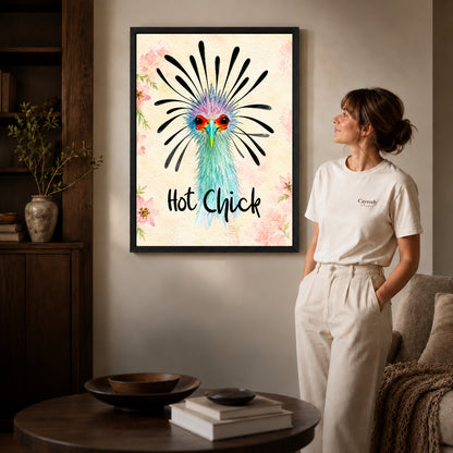 playful hot chick canvas art in a black frame beside a woman and round wooden table.