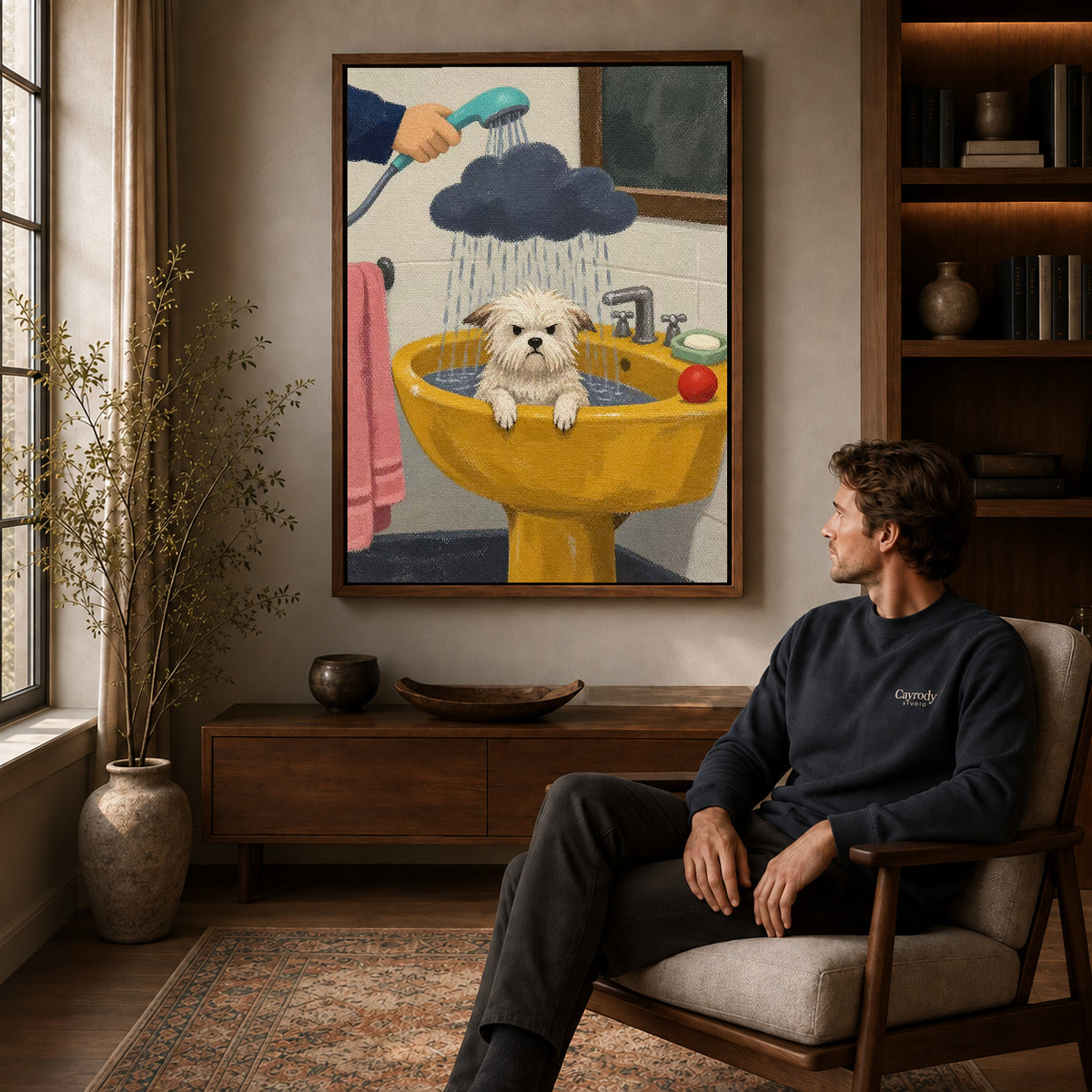 playful puppy bath canvas art in a walnut frame above a console beside a seated man.
