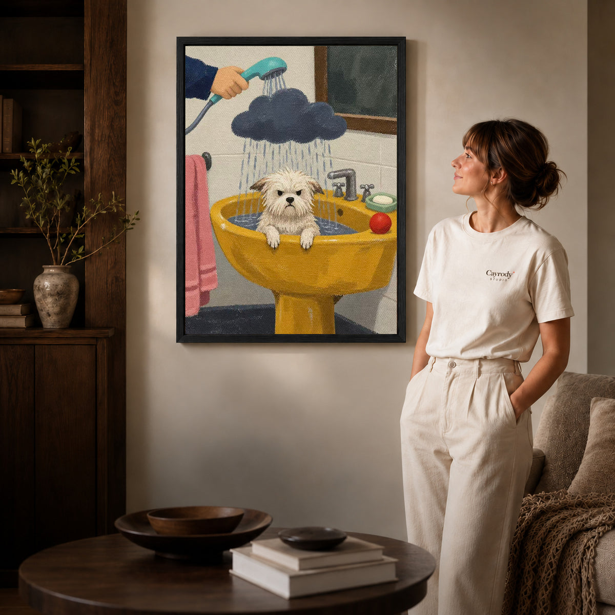 playful puppy bath canvas art in a black frame beside a woman and round wooden table.
