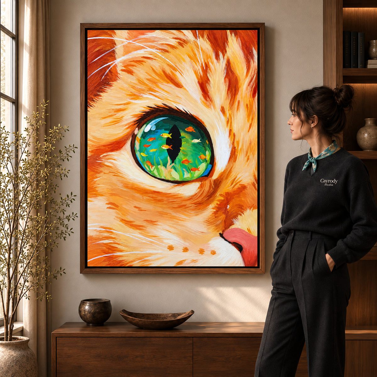 surreal aquarium cat canvas art in a walnut frame beside a standing woman and wooden console.