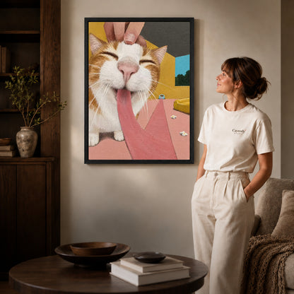 blissful long tongue cat canvas art in a black frame beside a woman and round wooden table.