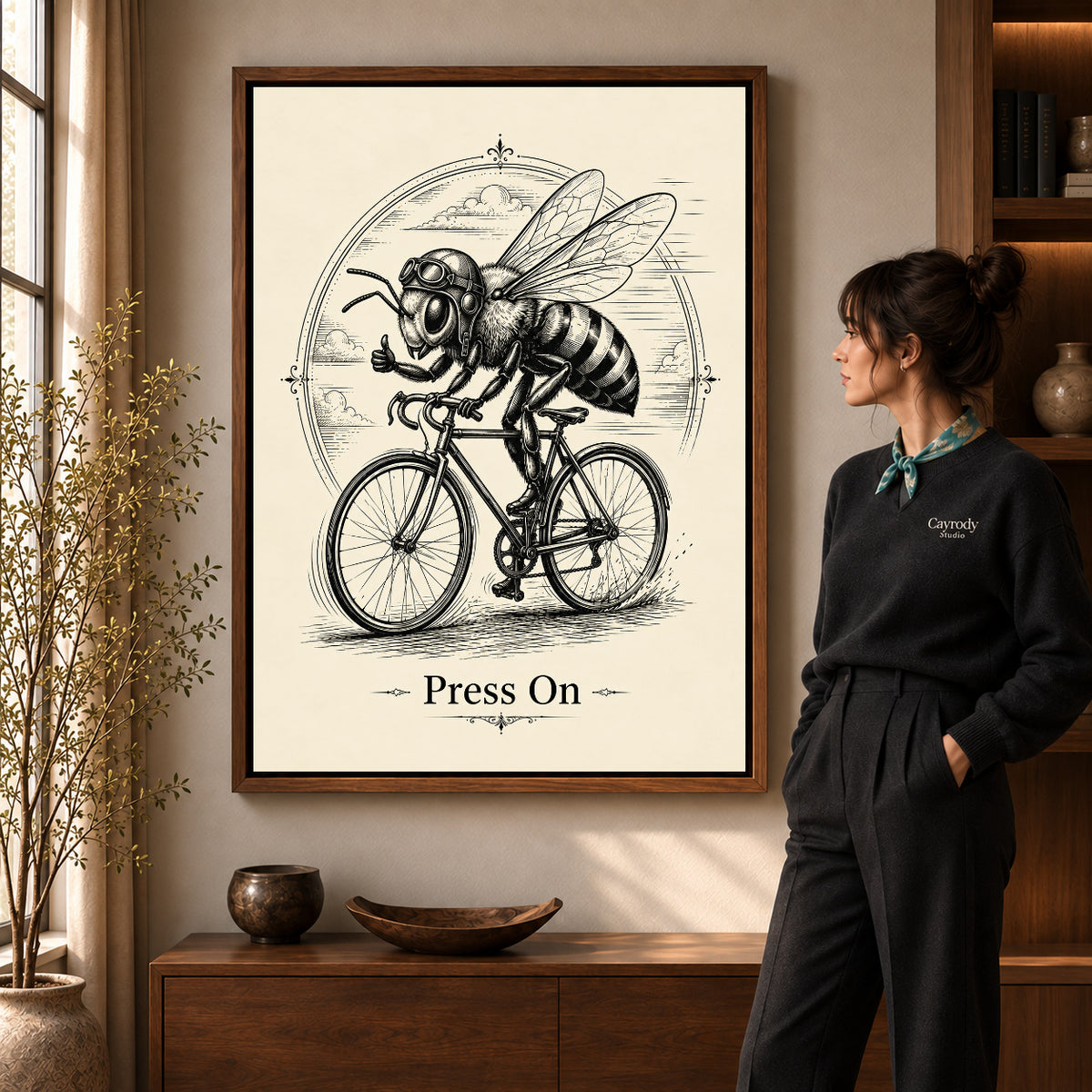 vintage cycling bee canvas art in a walnut frame beside a standing woman and wooden console.