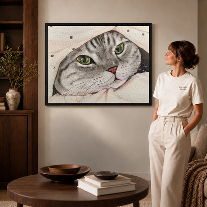 cozy blanket tabby canvas art in a black frame beside a woman and round wooden table.