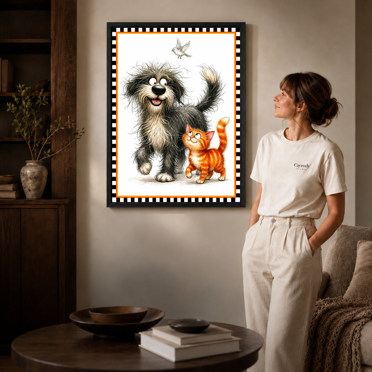playful pet companions canvas art in a black frame beside a woman and round wooden table.