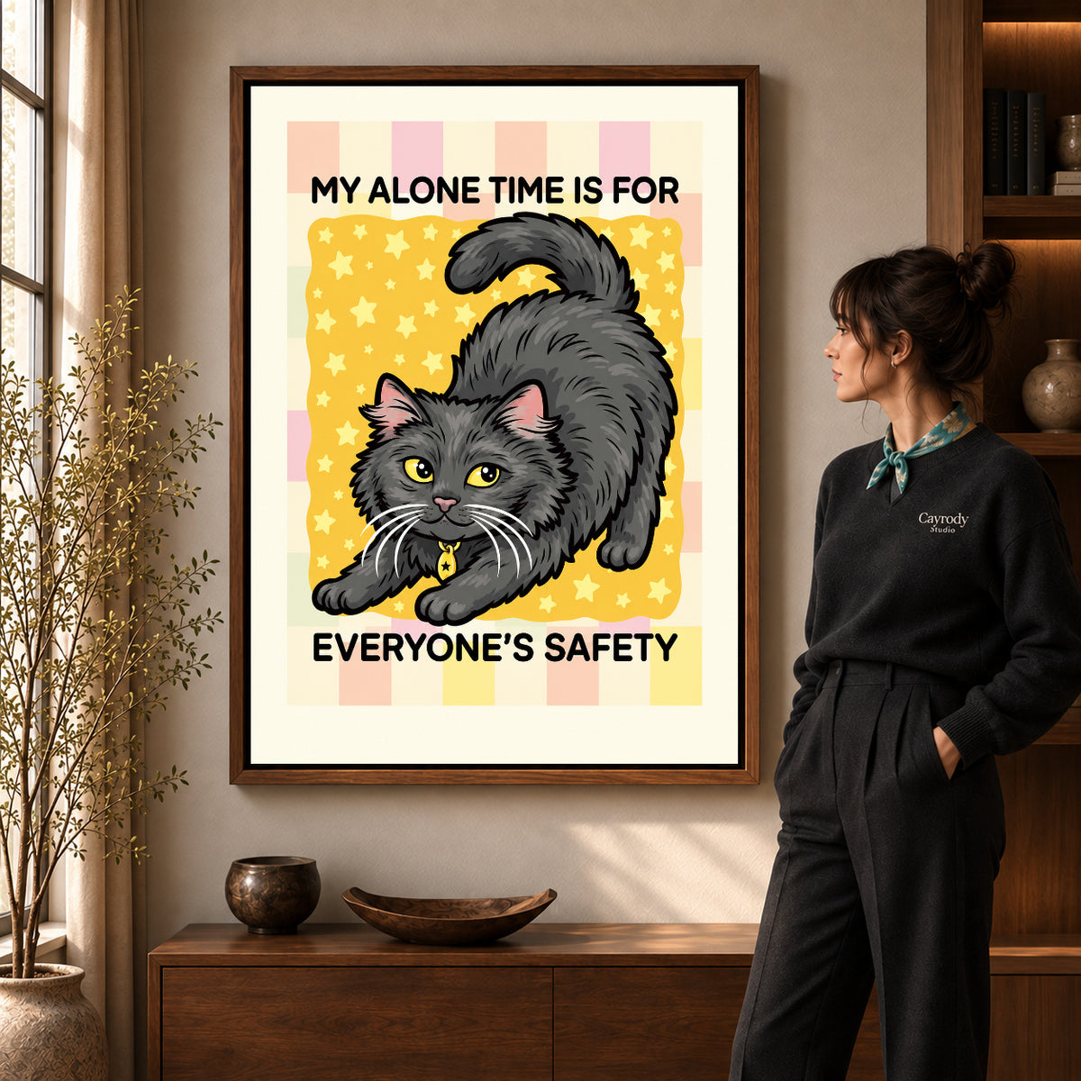 playful alone time cat canvas art in a walnut frame beside a standing woman and wooden console.