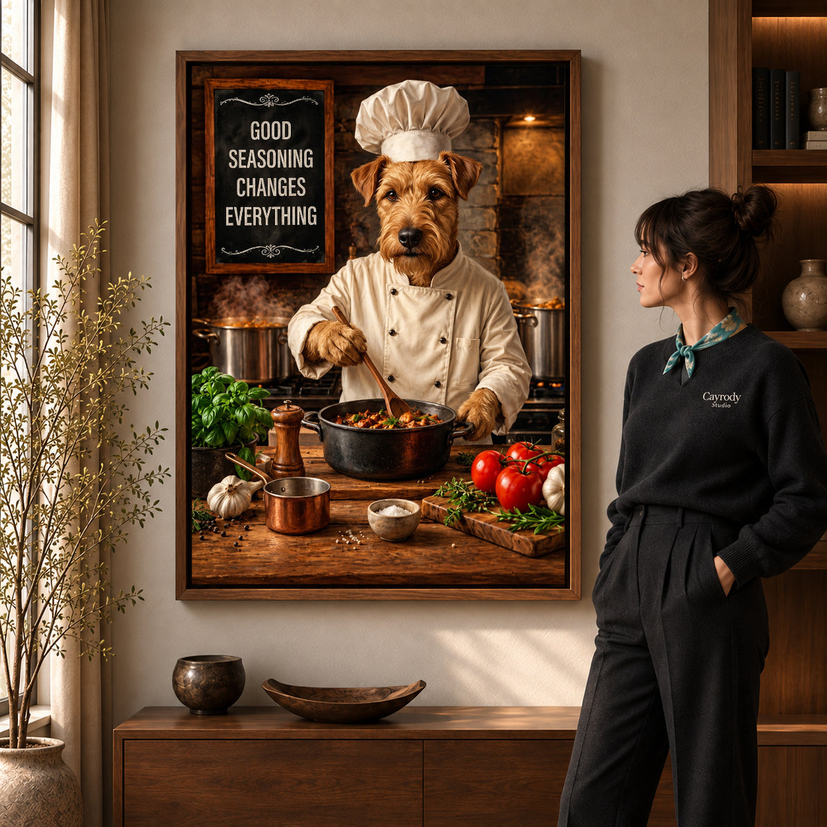warm terrier chef canvas art in a walnut frame beside a standing woman and wooden console.