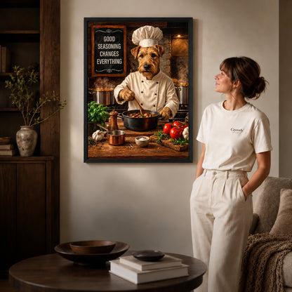 warm terrier chef canvas art in a black frame beside a woman and round wooden table.