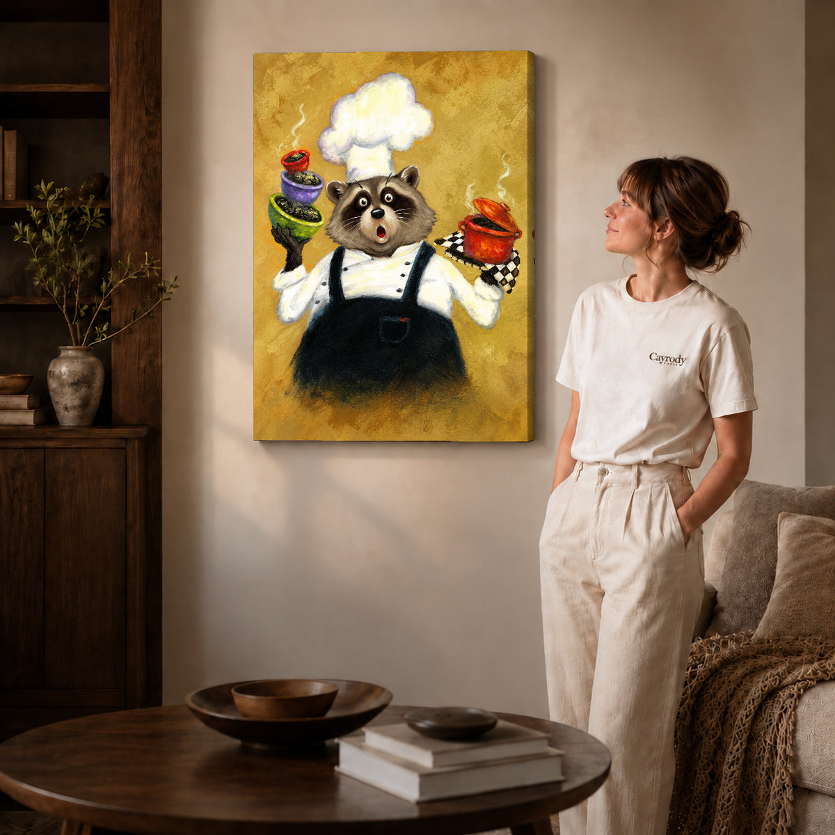 playful raccoon chef canvas art on gallery-wrapped canvas with natural edge shading beside a standing woman.