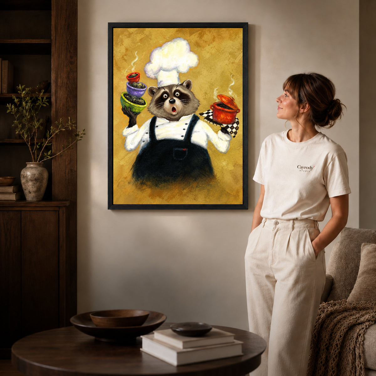 playful raccoon chef canvas art shown in the black frame option against a softly lit wall.