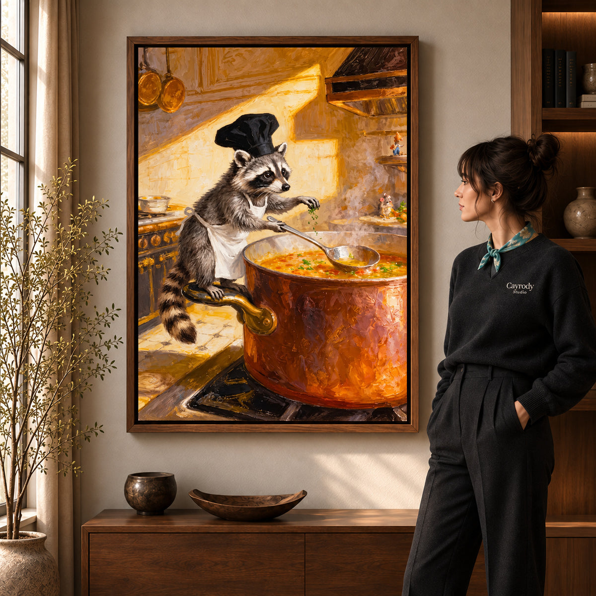 warm raccoon soup chef canvas art in a walnut frame beside a standing woman and wooden console.