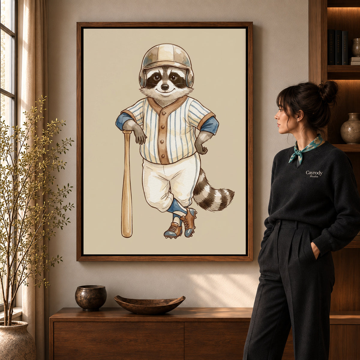vintage baseball raccoon canvas art in a walnut frame beside a standing woman and wooden console.