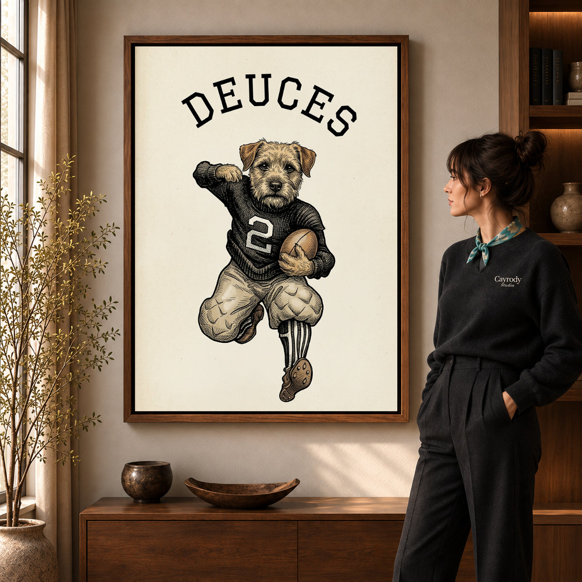 vintage football terrier canvas art in a walnut frame beside a standing woman and wooden console.