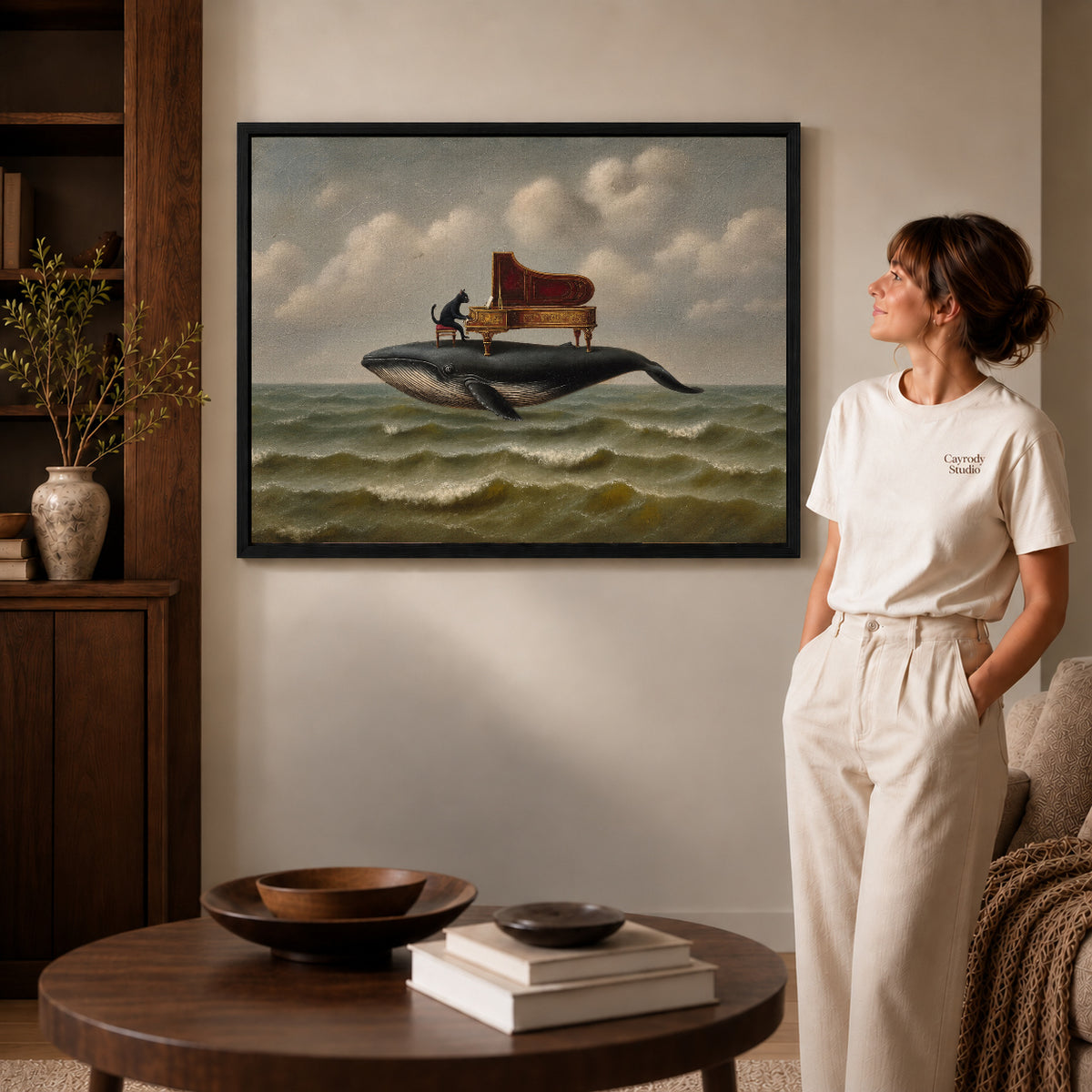 whale piano serenade canvas art in a black frame beside a woman and round wooden table.