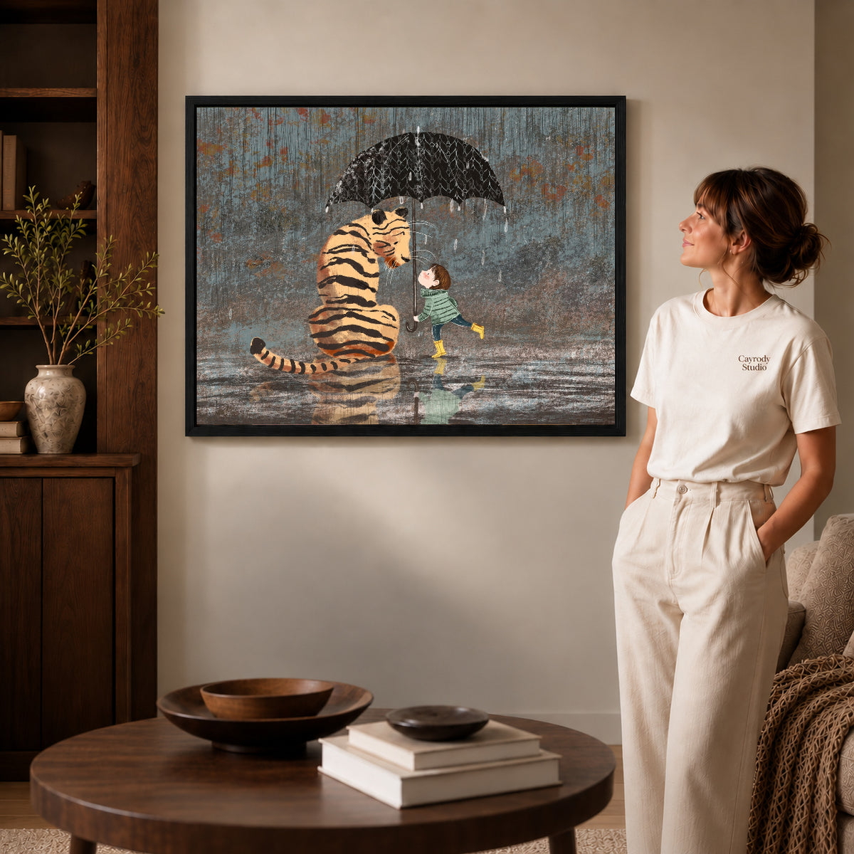 rainy tiger friendship canvas art in a black frame beside a woman and round wooden table.