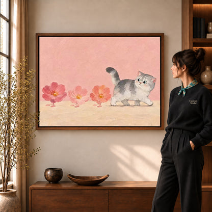 sweet blossom kitten canvas art in a walnut frame beside a standing woman and wooden console.