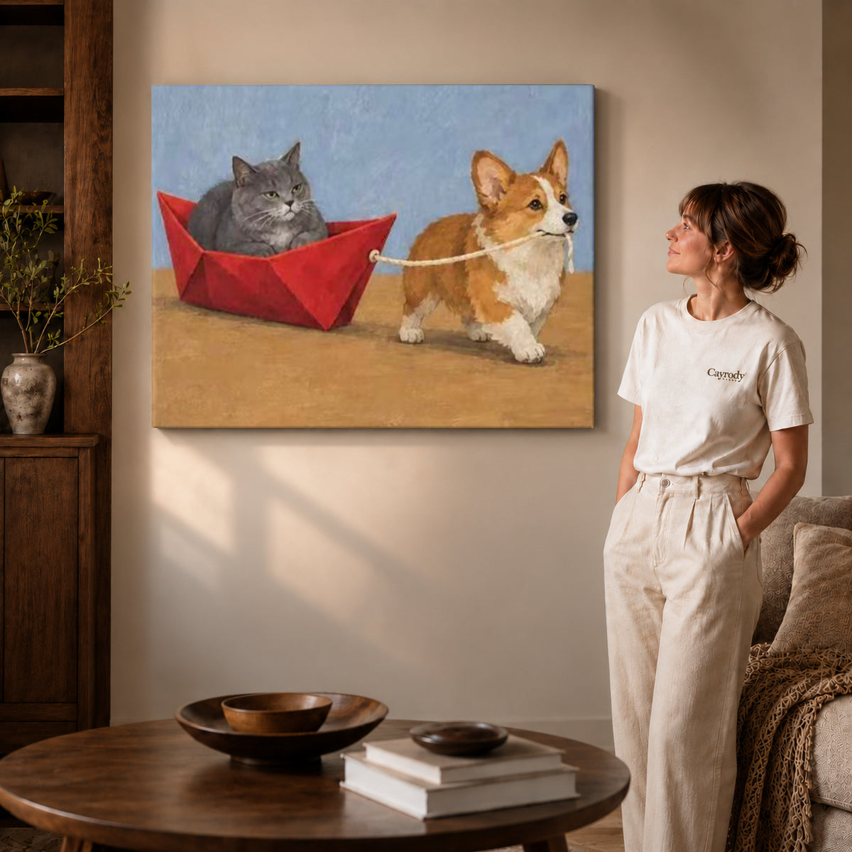 corgi cat boat adventure canvas art on gallery-wrapped canvas with visible edge depth beside a standing woman.