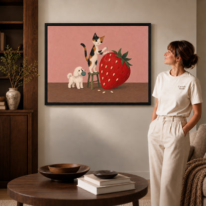 strawberry sewing friends canvas art in a black frame beside a woman and round wooden table.