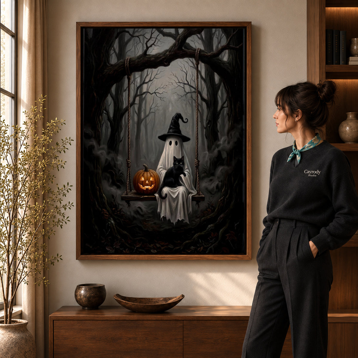 woodland ghost cat swing canvas art in a walnut frame beside a standing woman and wooden console.