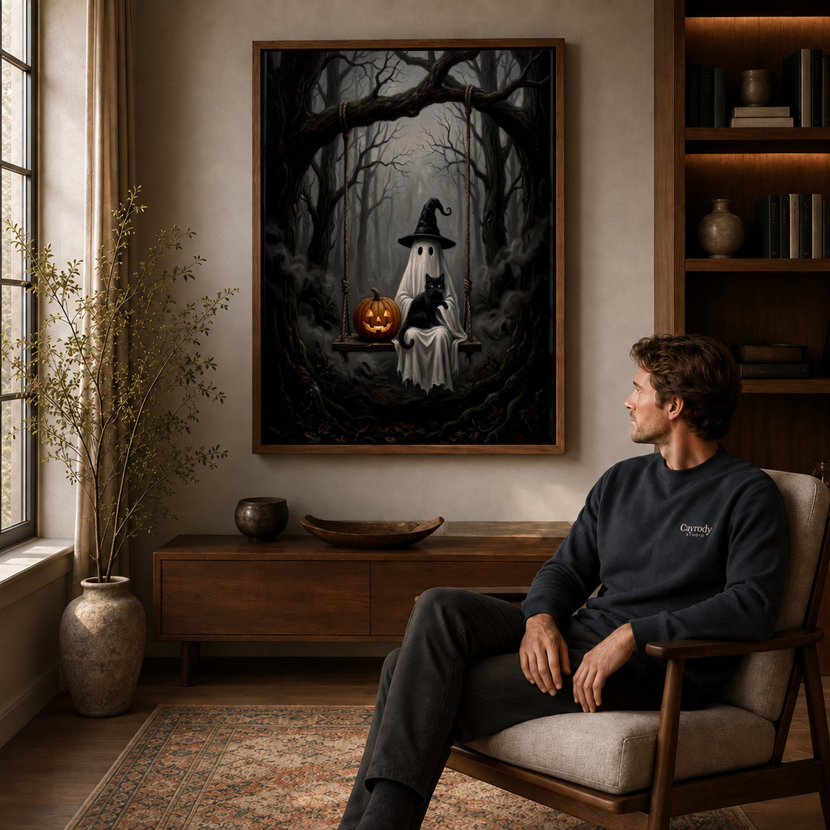 woodland ghost cat swing canvas art in a walnut frame above a console beside a seated man.