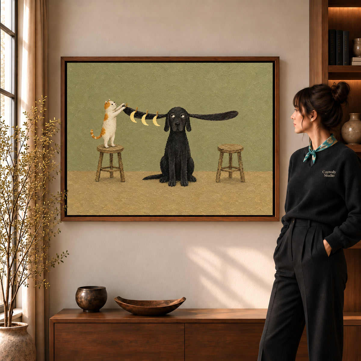 moon hanging pet friends canvas art in a walnut frame beside a standing woman and wooden console.