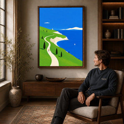 bright coastal path canvas art in a walnut frame above a console beside a seated man.
