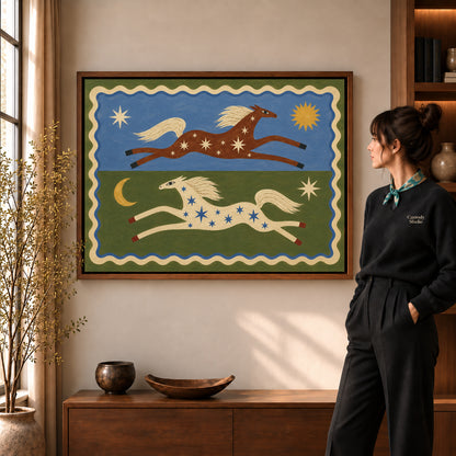 celestial folk horses canvas art in a walnut frame beside a standing woman and wooden console.