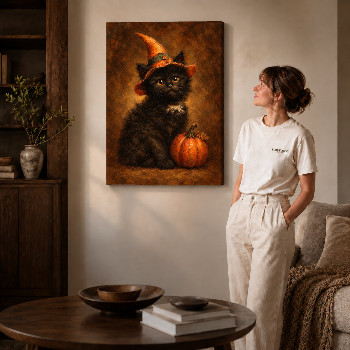 autumn witch kitten canvas art on gallery-wrapped canvas with natural edge shading beside a standing woman.