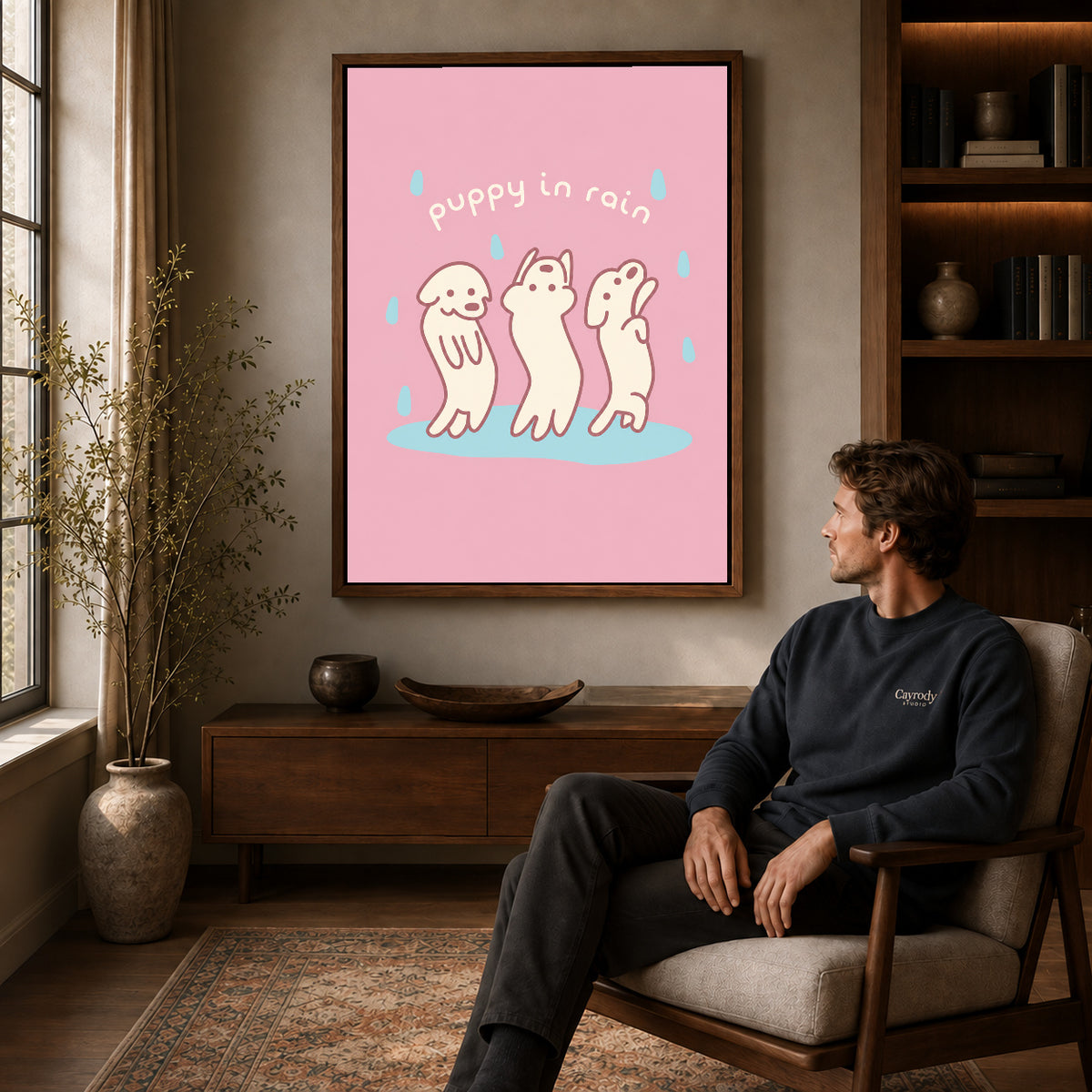 rain dancing puppies canvas art in a walnut frame above a console beside a seated man.