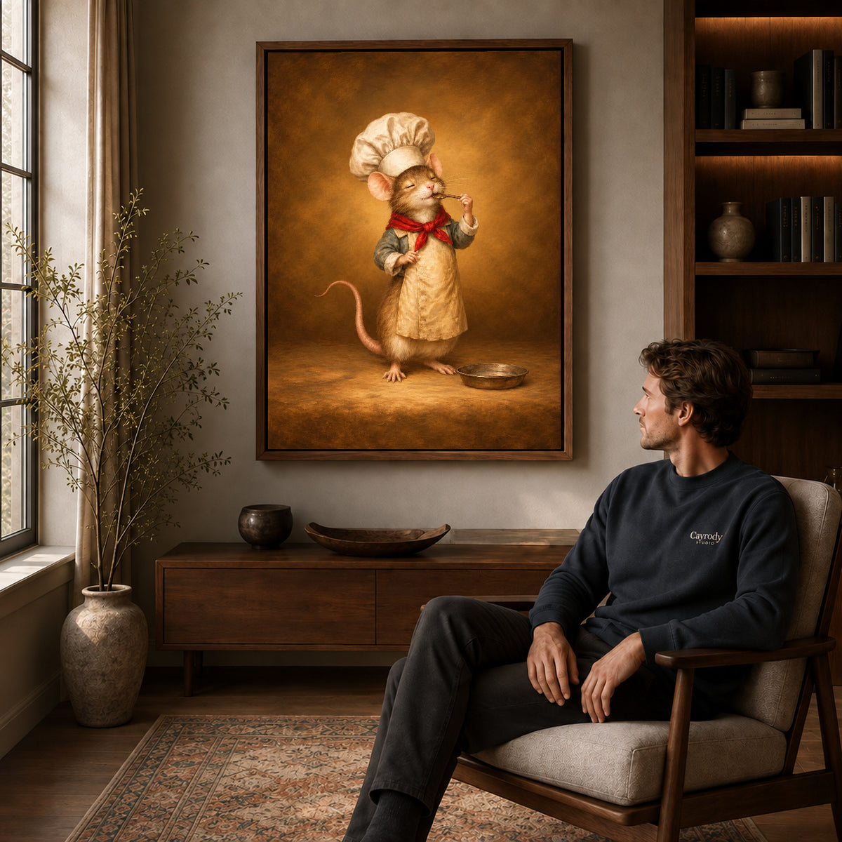 little mouse chef canvas art in a walnut frame above a console beside a seated man.