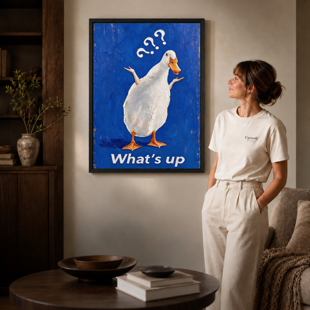 curious shrugging duck canvas art shown in the black frame option against a softly lit wall.