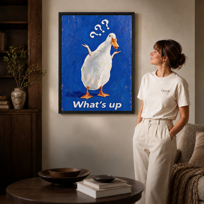 curious shrugging duck canvas art shown in the black frame option against a softly lit wall.