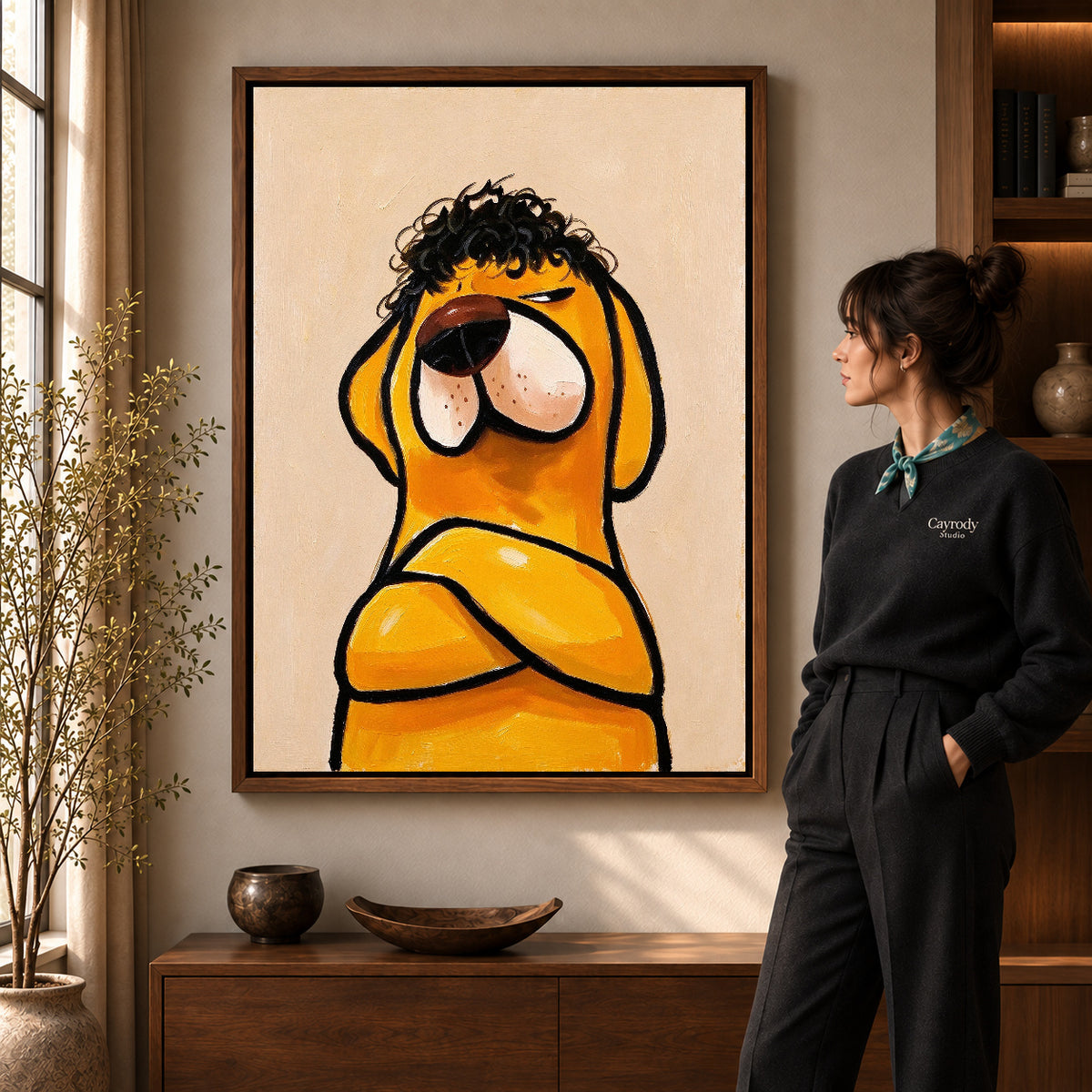 curly haired dog canvas art in a walnut frame beside a standing woman and wooden console.