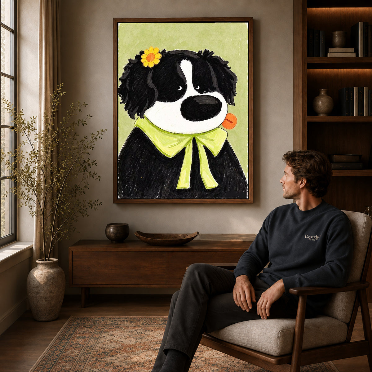 flower bow dog canvas art in a walnut frame above a console beside a seated man.